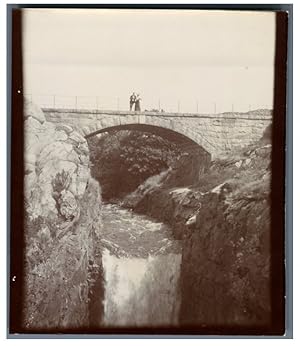 Couple prenant la pose sur un pont de pierre