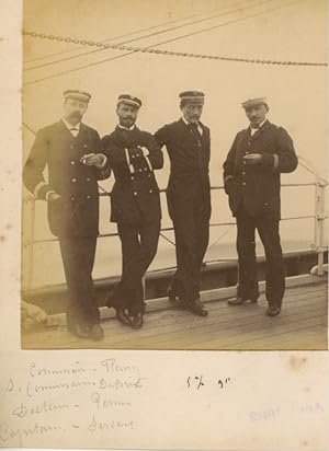 Sur un navire, Quatre hommes prennent la pose