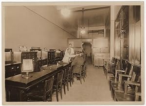 A photograph of the interior of the Optical Service Company as well as the proof copy of an adver...