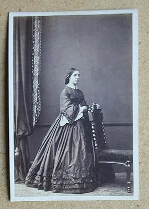 Carte De Visite Photograph. A Studio Portrait of a Young Woman, standing beside a Chair.