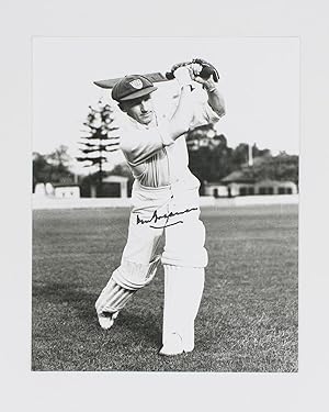 A signed photograph (black and white, 253 × 203 mm) of Don Bradman executing a straight drive