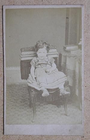 Carte De Visite Photograph. A Studio Portrait of a Seated Young Child Holding a Ball.