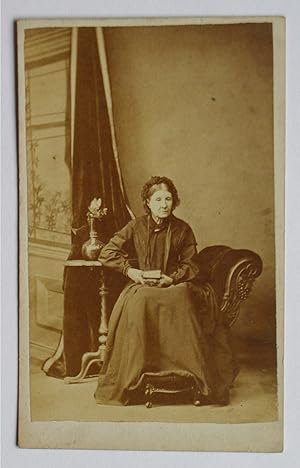 Carte De Visite Photograph. Studio Portrait of Seated Lady Holding a Book.