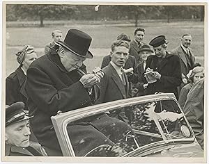 An original Second World War press photograph of Prime Minister Winston S. Churchill lighting a c...