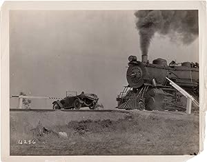 Original photograph from the lost film "The Scarlet Streak," circa 1926, of a car jumping a train...