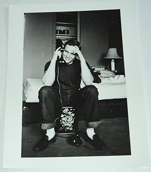 A BEAUTIFUL ORIGINAL PHOTOGRAPH OF A VERY YOUNG MARLON BRANDO, SEATED AT THE TELEPHONE IN FRONT O...