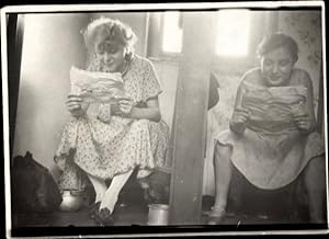 Foto Zwei Frauen lesen Zeitung auf dem Klo