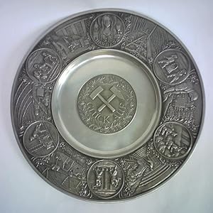 Dekorativer Zinnteller mit breitem Schmuckrand und rundem Emblem auf dem Tellerboden