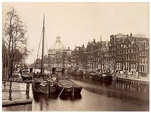 Nederland, Amsterdam, gracht met schepen op de achtergrond de Nieuwe Lutherse kerk