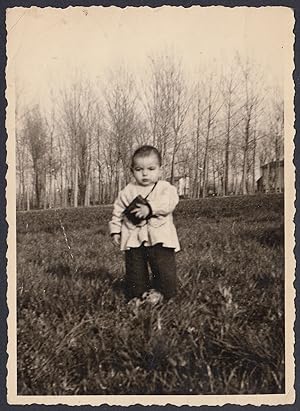Bambino di pochi mesi in piedi nella campagna, 1950 Fotografia vintage