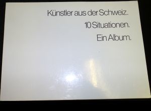 Künstler aus der Schweiz. 10 Situationen. Ein Album. Enthält unter anderem Arbeiten von Peter Emch, Rolf Hauenstein, Leiko Ikemura, Urs Lüthi, Markus Raetz, Hans Schärer, Philippe Schibig, Hugo Suter, Aldo Walker, Rolf Winnewisser etc. Ausstellung des Instituts für moderne Kunst Nürnberg in der SchmidtBank-Galerie 8.12. 1983 - 27.1. 1984.