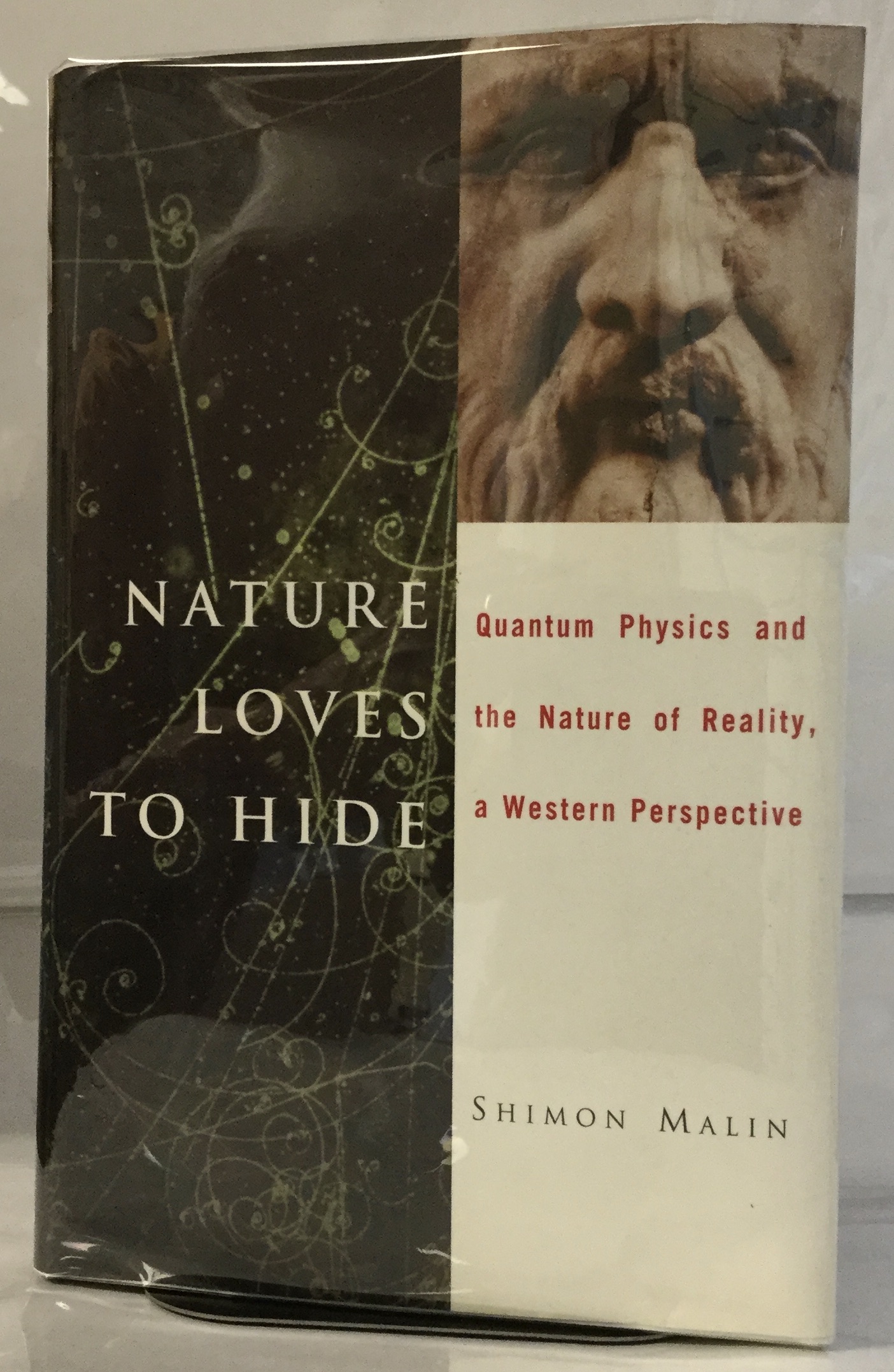 Nature Loves to Hide Quantum Physics and Reality, a Western Perspective Malin, Shimon [Very Good] [Hardcover] VG, in NF DJ. First printing. Minimal signs of wear to exterior, binding solid and straight, some underlining and marginal notations with ink marks on outer edge detract, else interior clean and unmarked. Unclipped jacket bright and fully intact. Clearly read, but a nice copy in a very nice jacket. Presentation letter signed by author together with enclosed essay by author laid in.
