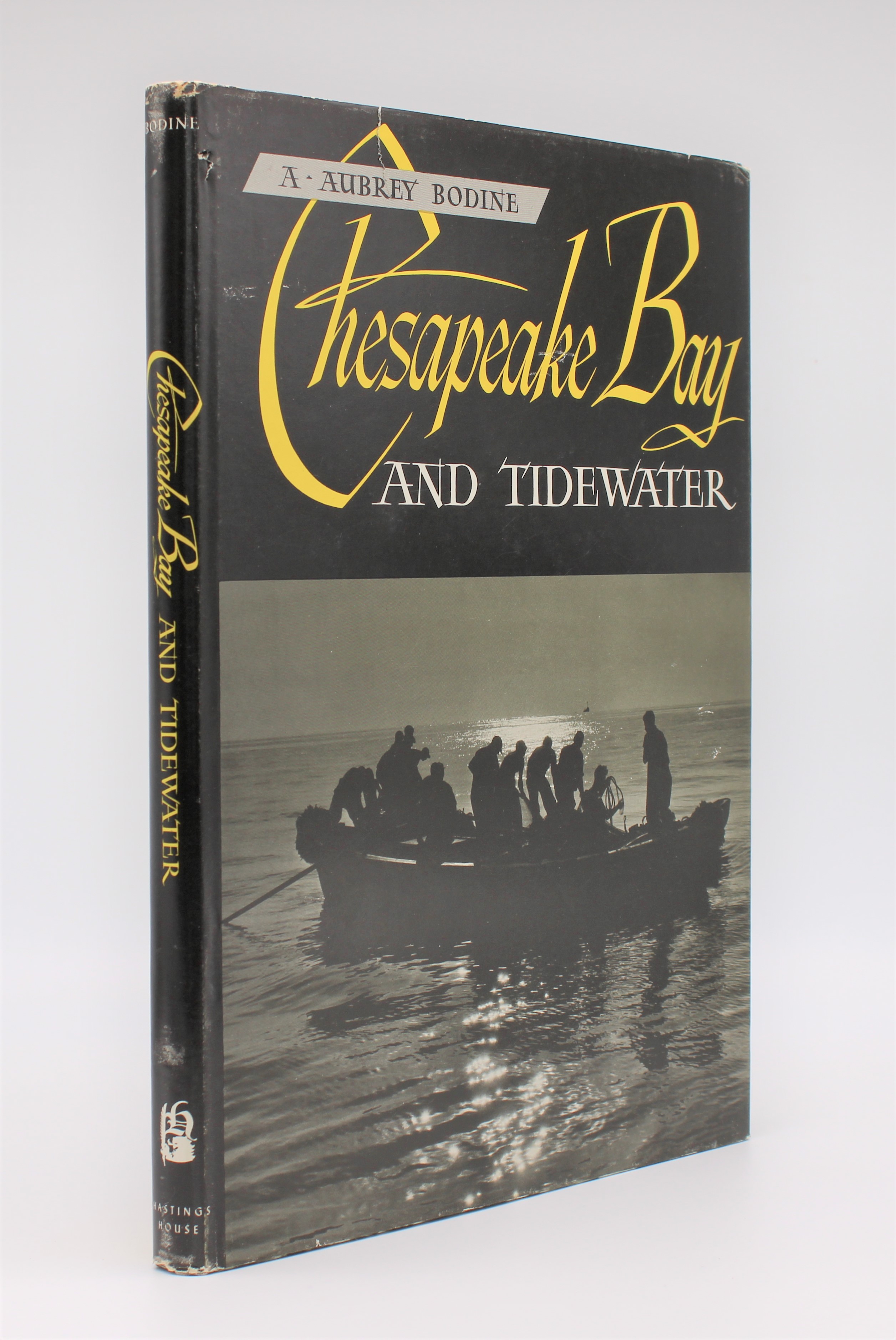 CHESAPEAKE BAY AND TIDEWATER Bodine, A. Aubrey [Very Good] [Hardcover] 144 pages. Map endpapers. A book of superb black and white photographs by A. Aubrey Bodine, award-winning photographer for the Baltimore Sun newspaper. The cloth covers have a wraparound photograph of sailboats on the Chesapeake Bay. The book is clean and tight, with some minor foxing on edges of the textblock (but not on the pages). The dust jacket is clean and bright with a hint of edgewear and two closed tears on the top edge (one is 3/4 inch long; the other 3/8 inch). Size: Folio - over 12  - 15  tall