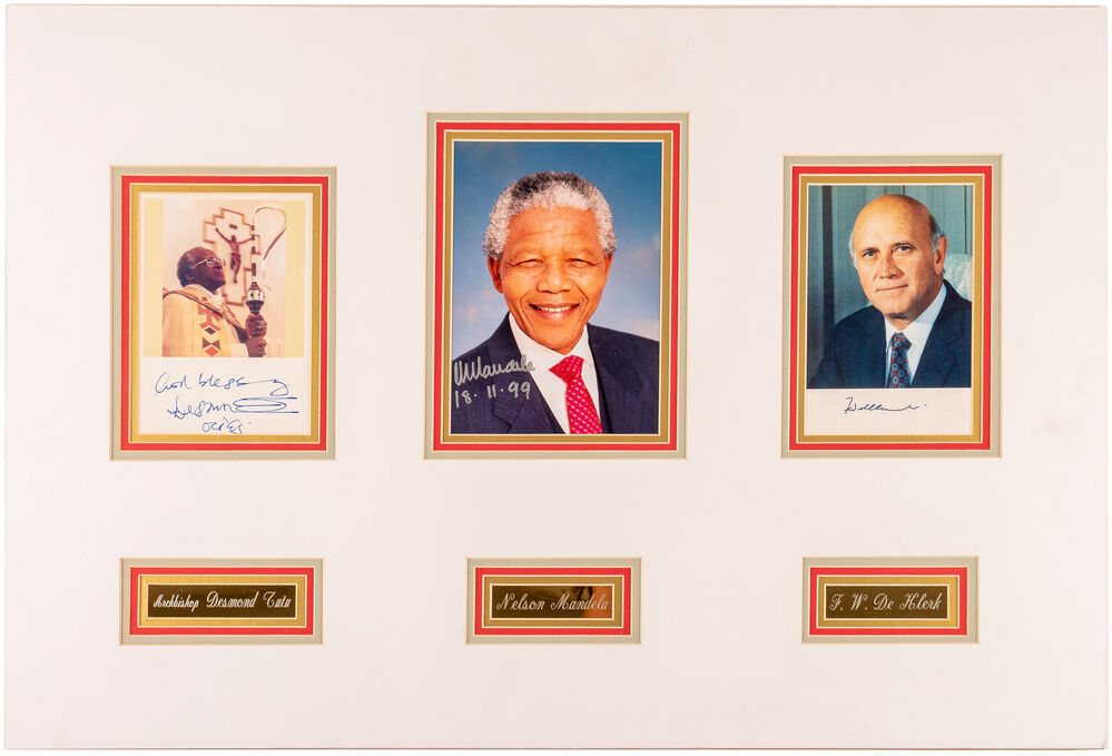 Three signed colour photographs in one mount, each with engraved metal name plate underneath. NELSON MANDELA, DESMOND TUTU , and F. W. DE KLERK [ ]