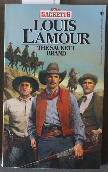 THE SACKETT BRAND. - #7 in the Sacketts Series. by L'AMOUR, LOUIS 1908-1988  (pseudonym of Louis Dearborn Lamoore);, Based on Screenplay By James R.  Webb;: Fine Soft Cover (1985) 48th Edition By