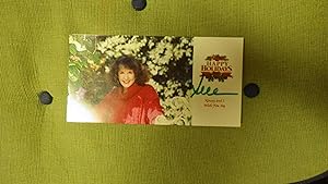 Bild des Verkufers fr SUE GRAFTON Smiling in Red Sweater By Foilage of White & Green, Her Personally SIGNED Christmas Card with First Name SUE, & A COLOR Photograph of Her on it. American Author of Detective Novels. Printed in Red it Reads Happy Holidays Kinsey & I, WishYouJoy zum Verkauf von Bluff Park Rare Books
