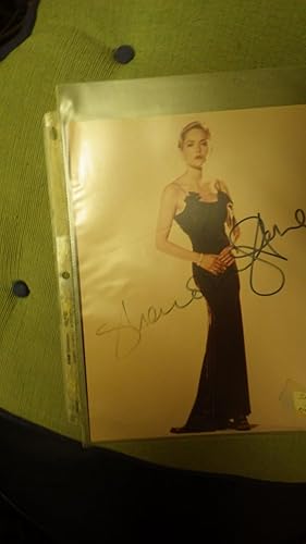 Seller image for Sharon Stone , Beautiful Thin Hollywood Actress Color Photograh , SIGNED in Black Ink, Standing Wearing Elegant Long Black Evening Dress with Short Blonde Hair & Red Lips, & Diamond Bracelet. for sale by Bluff Park Rare Books