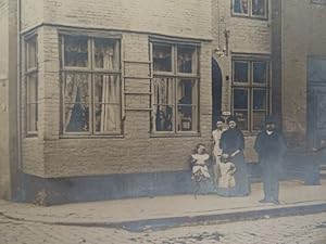 Familie vor Wohnhaus. Fotografie aus der Photographischen Kunstanstalt Rud. Fehring. Hamburg, um ...