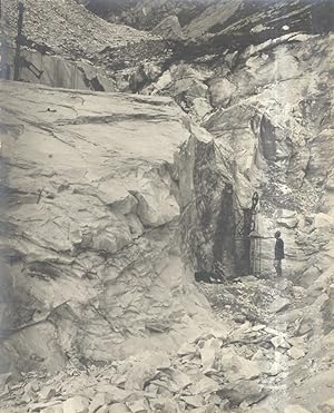 Fotografia originale d'una cava di marmo a Carrara: raffigura una persona in piedi, posta a fianc...