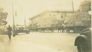 Imagen del vendedor de B&W Photograph of Intersection with Hay-Stacked Horse-Drawn Carriages and Packards. a la venta por Wittenborn Art Books