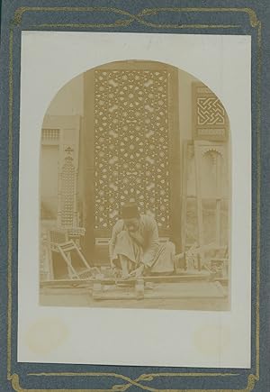 Menuisier arabe au travail devant une porte ornementée