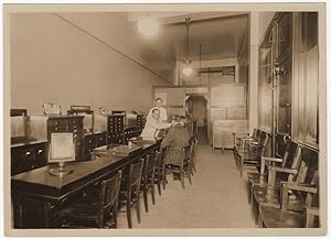 A photograph of the interior of the Optical Service Company as well as the proof copy of an adver...