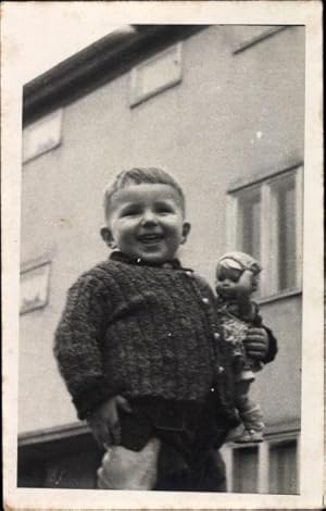 Bild des Verkufers fr Foto Ansichtskarte / Postkarte Lachender kleiner Junge mit Puppe im Arm zum Verkauf von akpool GmbH