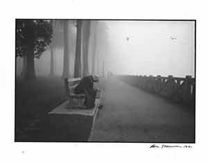 Portrait of man kneeling on bench.
