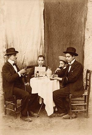 Italian rural scene Four young bon vivants playing cards and drinking wine 1900c