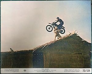 Image du vendeur pour 'The Losers' Original Film Lobby Card, iconic image of bike jumping grass hut and Viet Cong fighter. mis en vente par Rattlesnake Books
