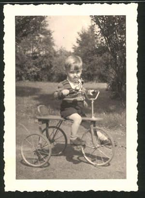 Fotografie niedlicher Knabe fährt Dreirad