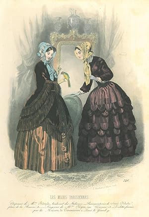 MODE. Zwei junge Frauen in dunklen Kleidern, die eine hat einen Kanarienvogel auf der Hand sitzen...
