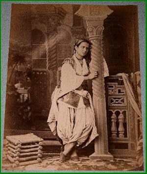 Bild des Verkufers fr Grande photographie anciennes originale (Vers 1880). Tirage photographique sur papier albumin contrecolle sur carton reprsentant une femme arabe  l'intrieur d'une maison. zum Verkauf von JOIE DE LIRE