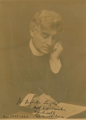 Portrait photograph of David Belasco writing with quill pen
