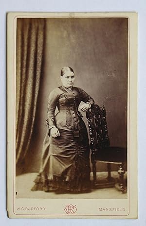 Seller image for Carte De Visite Photograph. Studio Portrait of a Woman Wearing a Fine Dress Beside a Chair. for sale by N. G. Lawrie Books