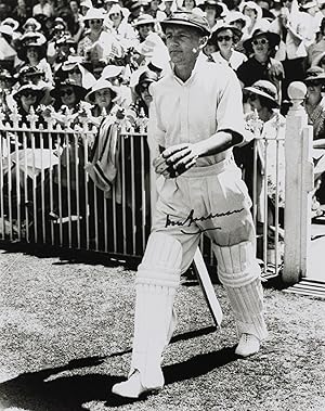 A signed photograph (black and white, 253 × 203 mm) of Don Bradman walking out to bat