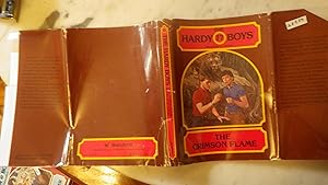 Image du vendeur pour The Crimson Flame #77 in the Hardy Boys series.in Color BROWN Dustjacket of 2 boys one in Red shirt wearing watch & other in Blue shortsleeved shirt , both observing Small Item with Large Tiger mis en vente par Bluff Park Rare Books