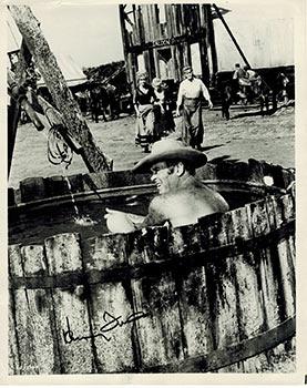 Photograph of Henry Fonda in a wooden tub in a Western. Signed.