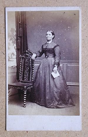 Carte De Visite Photograph. Studio Portrait of a Finely Dressed Lady Beside a Chair.