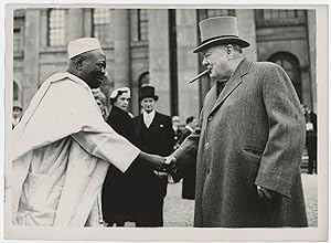 An original press photograph of Prime Minister Winston S. Churchill shaking hands with the Ooni o...