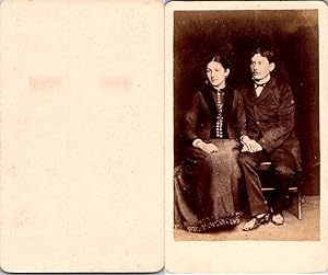 Un couple pose assis se tenant la main
