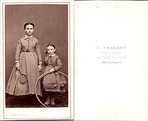 Fragney, Besançon, Deux petites filles se tenant la main, avec un cerceau et une raquette, circa ...