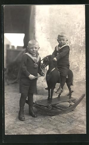 Foto-Ansichtskarte Zwei kleine Jungen in Matrosenanzügen mit einem Schaukelpferd