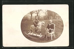 Foto-Ansichtskarte Zwei kleine Jungen mit einem Schaukelpferd im Freien