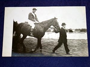 Bild des Verkufers fr Carte photo ancienne reprsentant un cheval de course, son jockey et le lad. zum Verkauf von JOIE DE LIRE