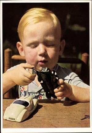 Ansichtskarte / Postkarte Sein liebstes Spielzug, Junge mit Spielzeugautos, Fotograf Wolf H. Döring