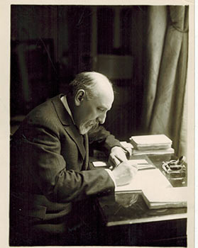 Original photograph of Luigi Pirandello writing, with verso manuscript.