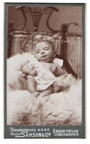 Bild des Verkufers fr Fotografie Samson, Co., Essen a. Ruhr, Limbeckerstr. 12, Portrait kleines Kind im Kleid auf einem Fell zum Verkauf von Bartko-Reher