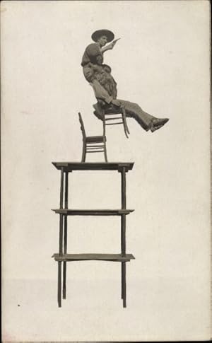 Foto Ansichtskarte / Postkarte Cowboy, Balanceakt auf Turm aus Tischen und Stühlen, Wild West Sch...