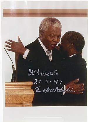 Colour photograph of Nelson Mandela and Thabo Mbeki embracing, signed by both and dated "27.9.99"